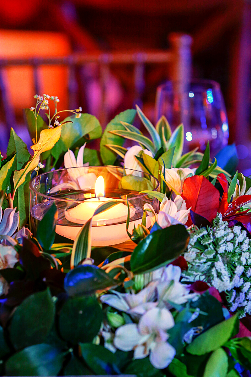 Floating tealight candle surrounded by flowers and a wine glass