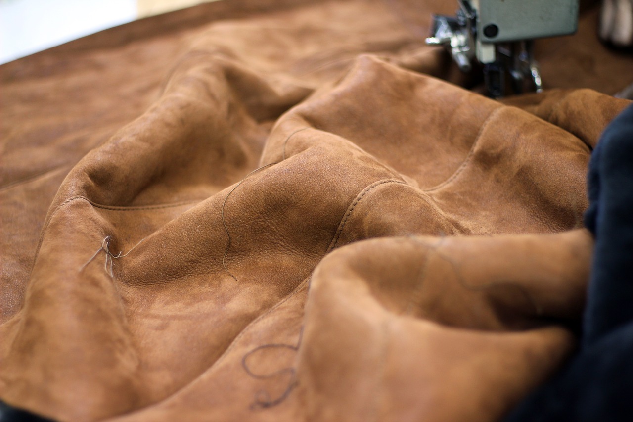 Brown leather or suede being sewn with a sewing machine