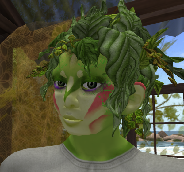 Inside a greenhouse, a green-skinned boy looks to the left of the viewer. His expression is serious. His hair looks like the leaves of a bush.
