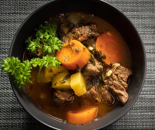 Photograph of a bowl of stew with meat and vegetables