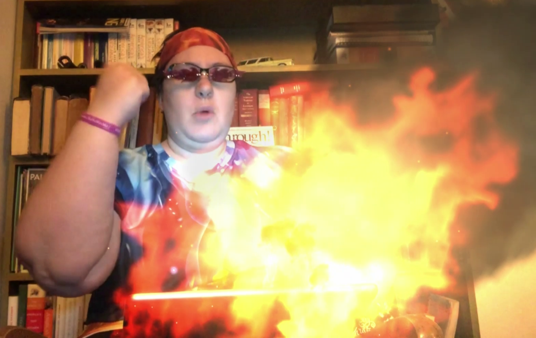 A writer with a laptop that is magically creating fire, pumping their fist