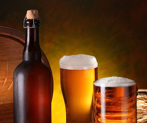 A wooden cask, a brown bottle, and two mugs of beer