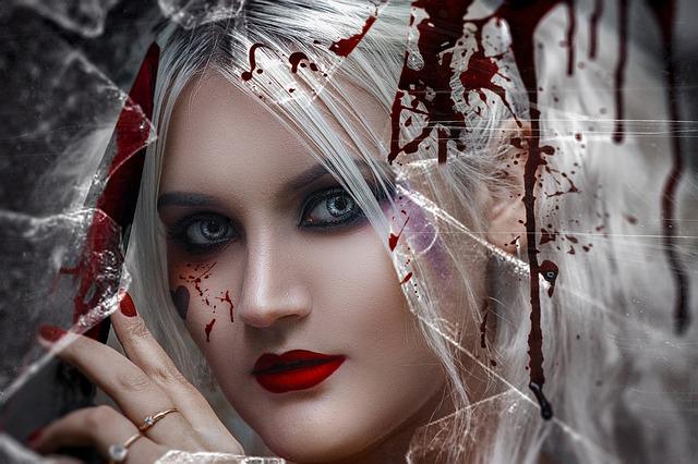 Stylized photo of a woman holding a bloody knife behind broken glass