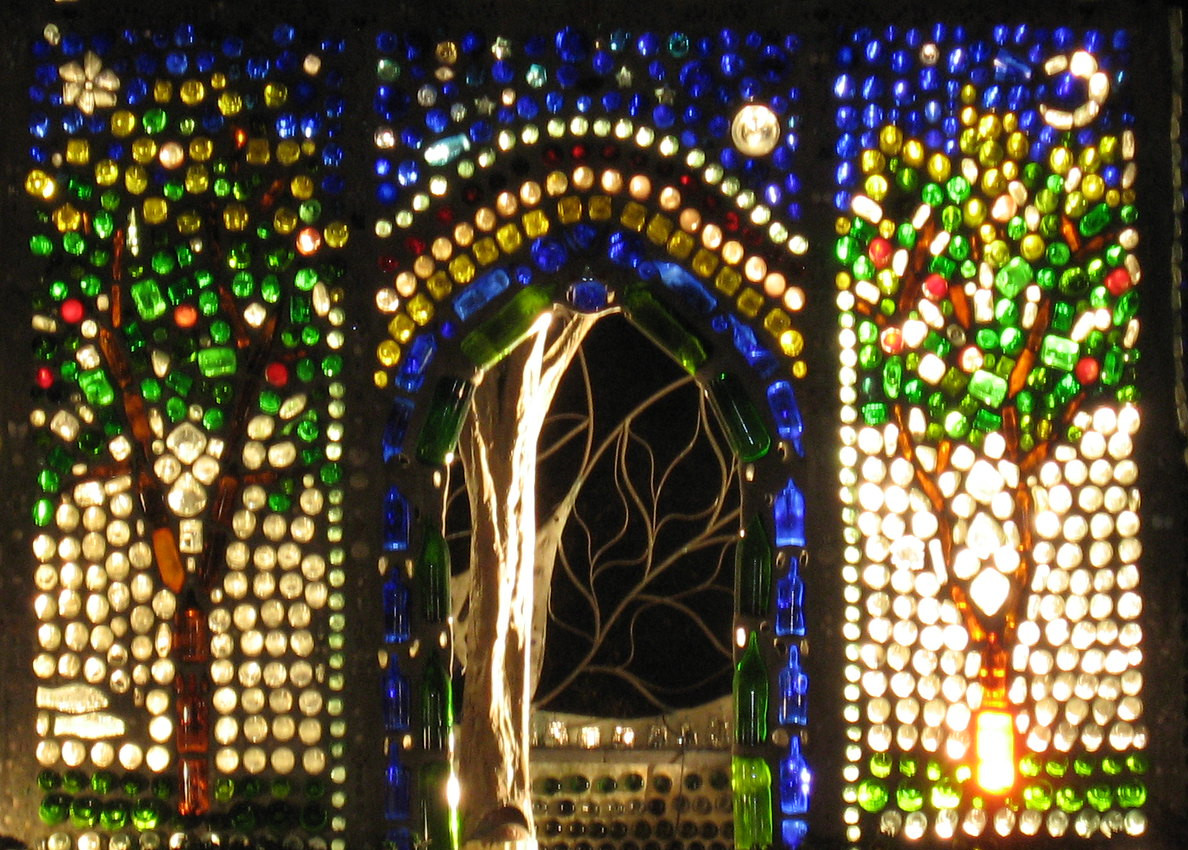 bottle wall displaying two trees and an archway