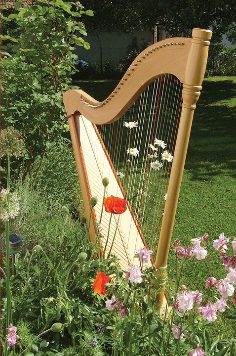A simple wooden harp in a flower garden on a summer day
