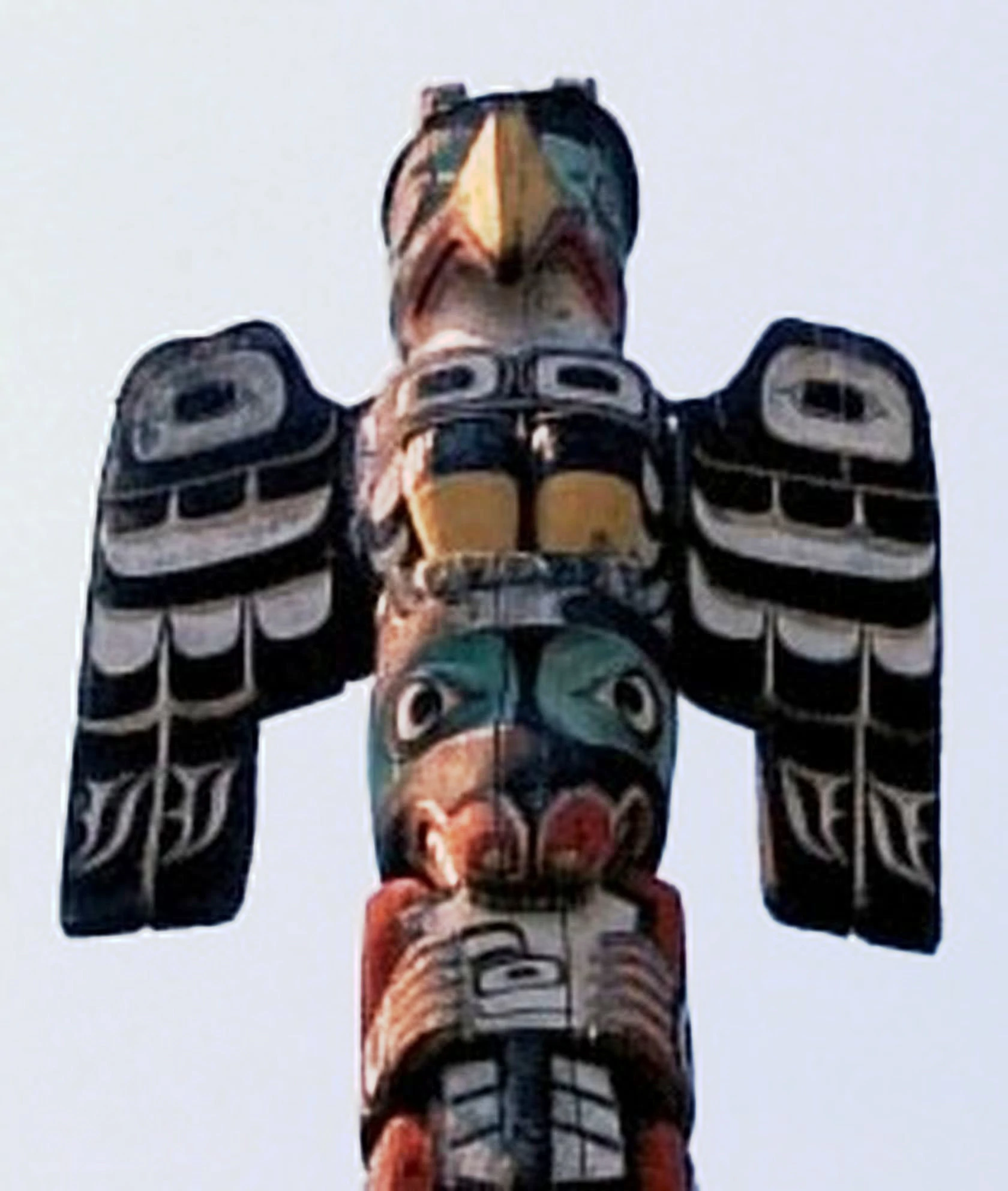 Photograph of an Native American Totem Pole with a thunderbird at the top.